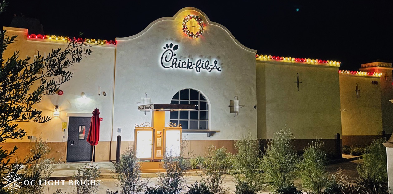 Chick-fil-A restaurant facade with an illuminated wreath and red and warm-white roofline lights