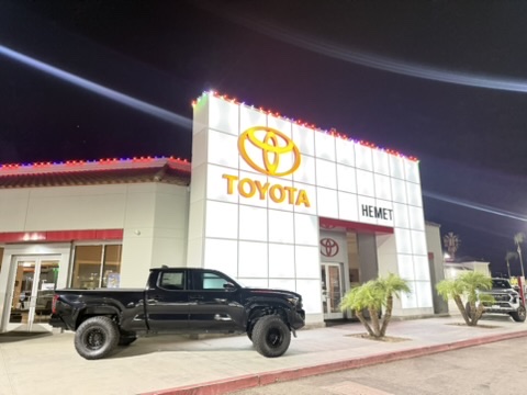 Toyota dealership in Hemet with colored holiday lights along its facade and roofline